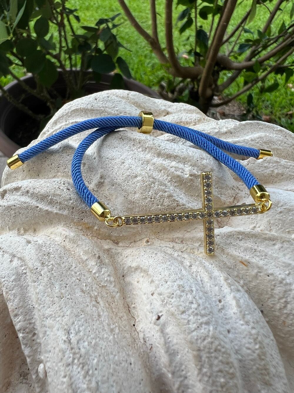 Adjustable blue gold plated cross bracelet.